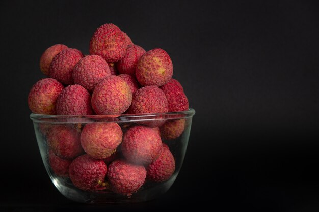 Rote Litschifrucht gelegt in einen Korb.