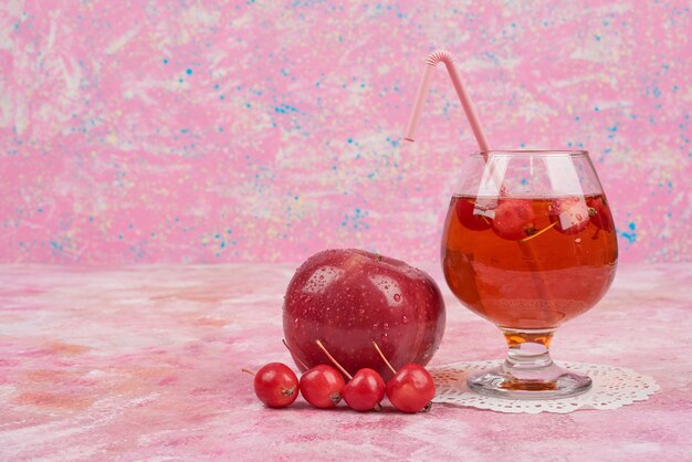 Rote Äpfel mit einem Glas Saft.