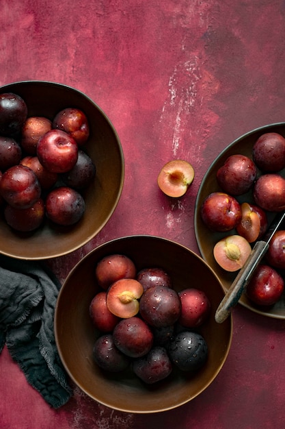 Kostenloses Foto rote pflaumen in einer schüssel sommerfutter flatlay