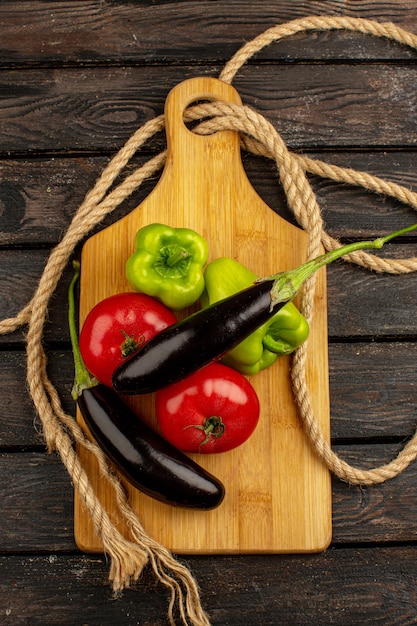 Rote reife frische Tomaten-Auberginen des frischen Gemüses und grüne Paprika auf einem braunen rustikalen Schreibtisch