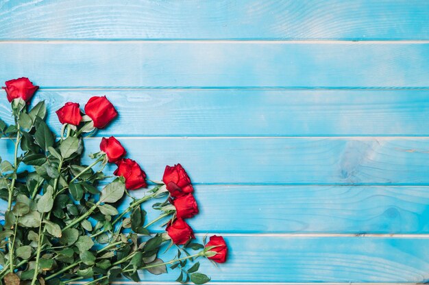 Rote Rosen auf blauem Tisch