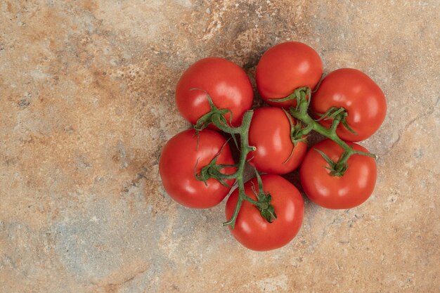 Rote Tomatenkirsche auf einem Zweig auf Marmoroberfläche