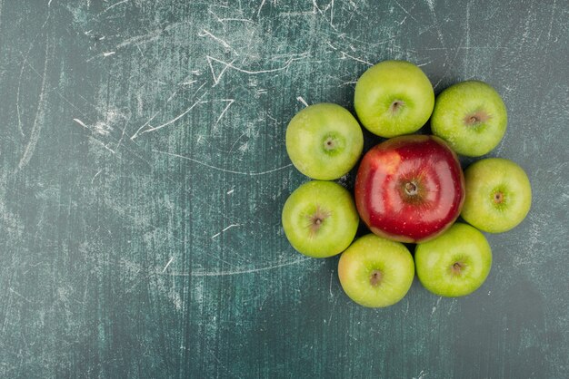 Rote und grüne Äpfel auf Marmortisch.