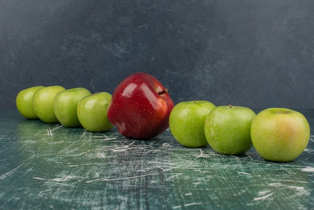 Rote und grüne Äpfel auf Marmortisch.