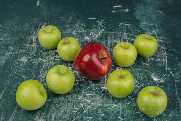 Rote und grüne Äpfel auf Marmortisch.