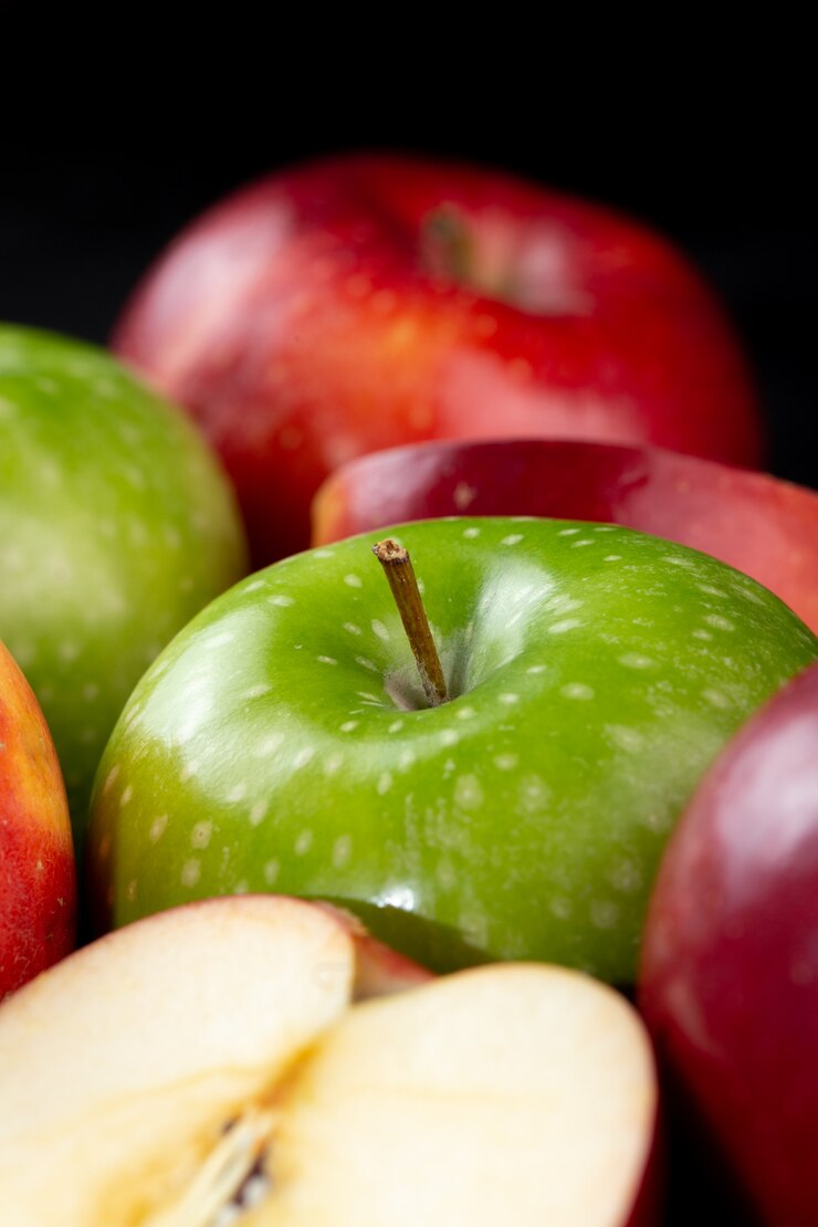 Kostenlose Foto rote und grüne saftige weiche äpfel der frischen früchte lokalisiert auf dunklem schreibtisch