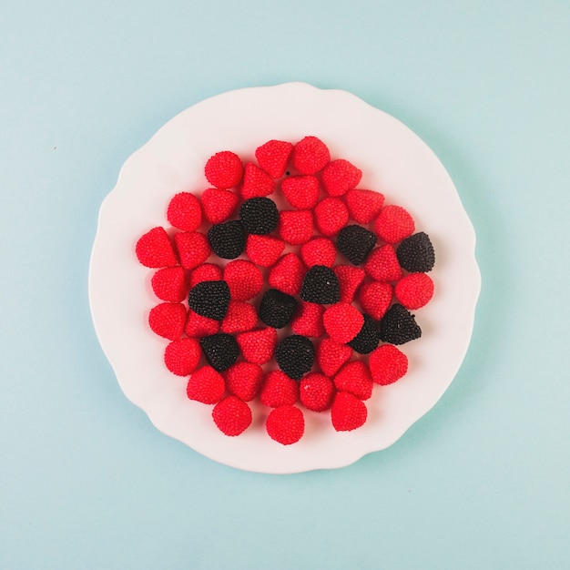 Rote und schwarze Moosbeersüßigkeiten auf Platte