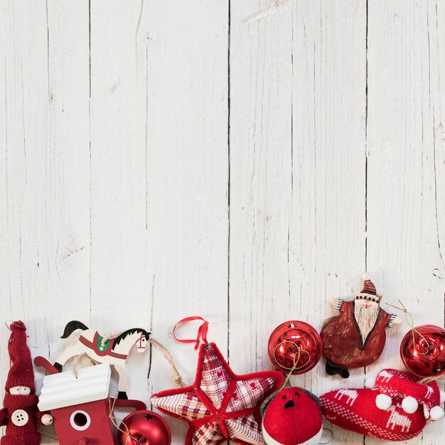 Rote Verzierungen für Weihnachtsbaum über weißem hölzernem Hintergrund