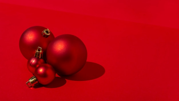 Kostenloses Foto rote weihnachtskugeln auf rotem tisch