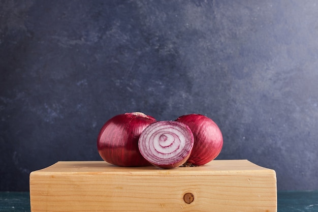 Kostenloses Foto rote zwiebel auf einem holzbrett.