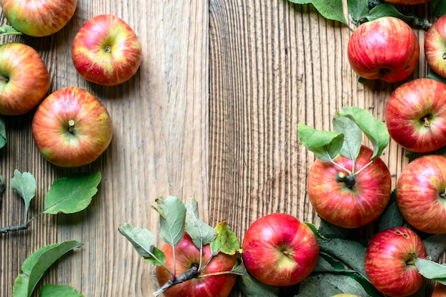 Roter Apfel und Blatt auf Holztisch