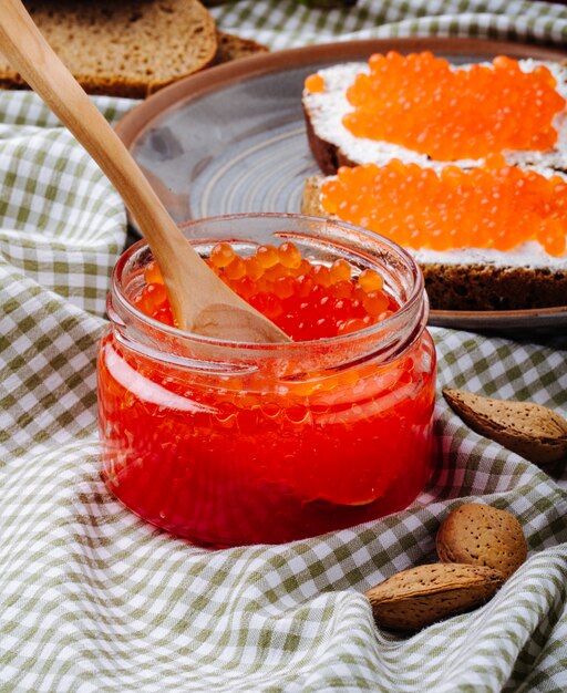 Roter Kaviar Toast Roggenbrot Seitenansicht mit Hüttenkäse roter Kaviar und Mandel auf dem Tisch