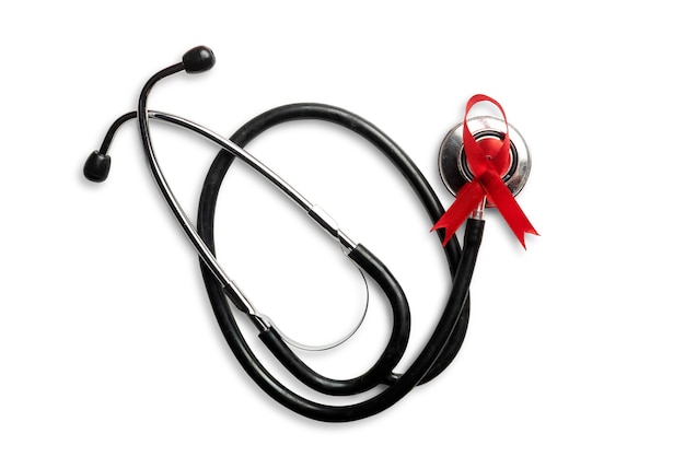 Rotes Band und Stethoskop mit weißem Hintergrund. Bewusstsein für das HIV-Aids-Band