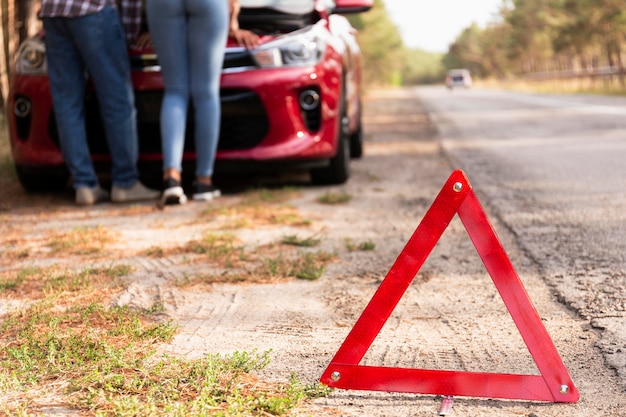 Rotes Dreieckzeichen auf der Straße für Autoprobleme während der Reise
