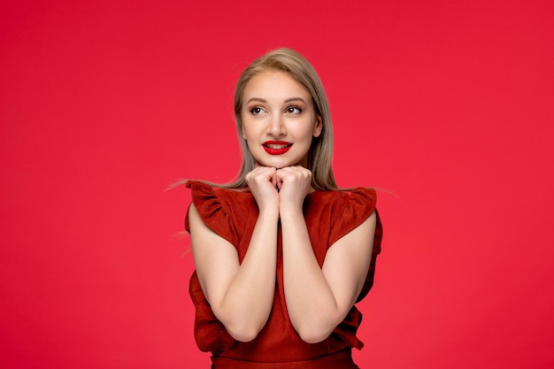 Rotes Kleid, süßes, elegantes Mädchen in weinrotem Kleid mit rotem Lippenstift, lächelnd und Händchen haltend