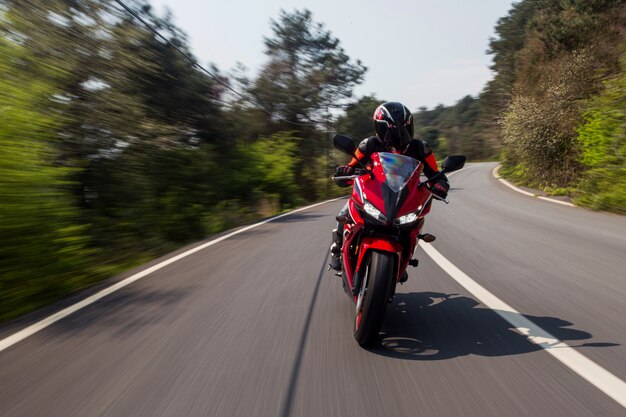 Rotes Motorrad, das auf die Straße fährt.