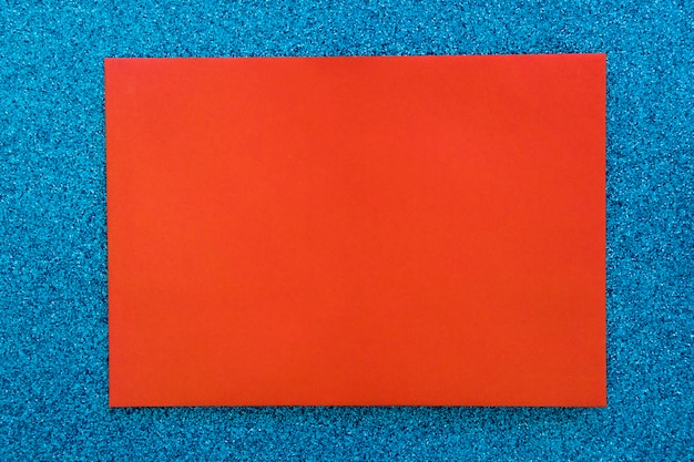 Rotes Papppapier auf blauem Funkelnhintergrund