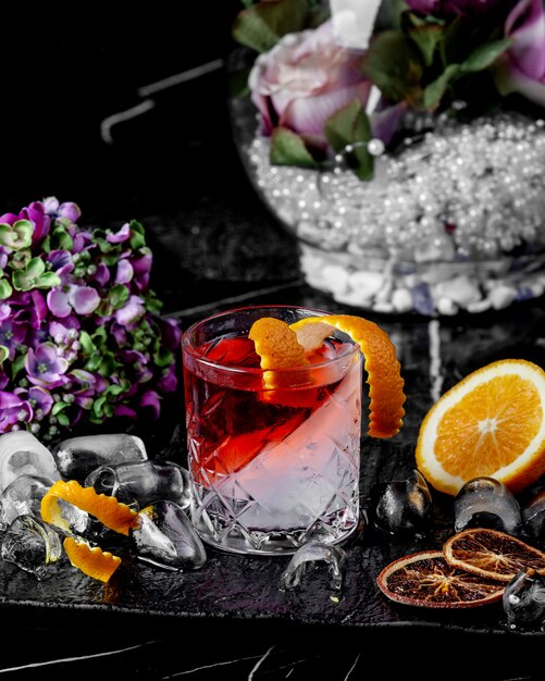 Rotes und weißes Cocktailglas mit Orangenschale