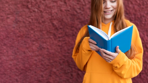 Rothaarige frau liest aus einem buch