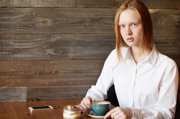 Rothaarige Frau sitzt im Café