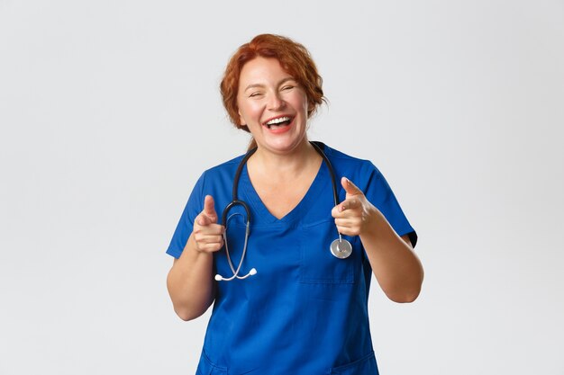 Rothaarige Krankenschwester mittleren Alters posiert