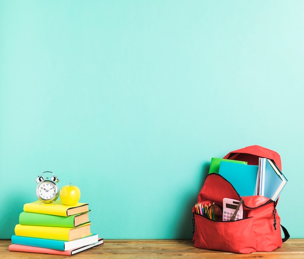 Kostenloses Foto rucksack und lehrbücher auf dem schreibtisch