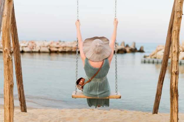 Rückansicht der älteren Touristenfrau in der Strandschaukel