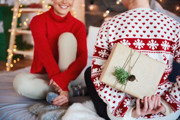 Rückansicht der Frau, die ihrem Freund Weihnachtsgeschenk gibt