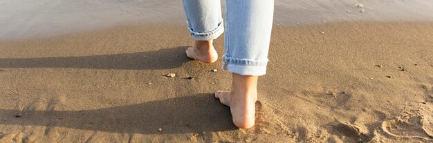 Rückansicht der Frauenfüße auf Sand