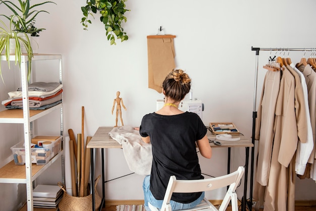 Rückansicht der Schneiderin, die im Studio arbeitet