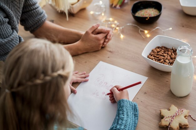 Rückansicht des Mädchens, das einen Brief an den Weihnachtsmann schreibt