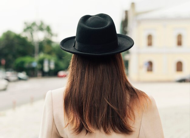 Rückansicht Frau, die einen schwarzen Hut trägt