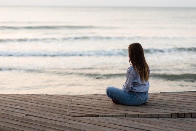 Rückansicht Frau, die nahe am Meer entspannt