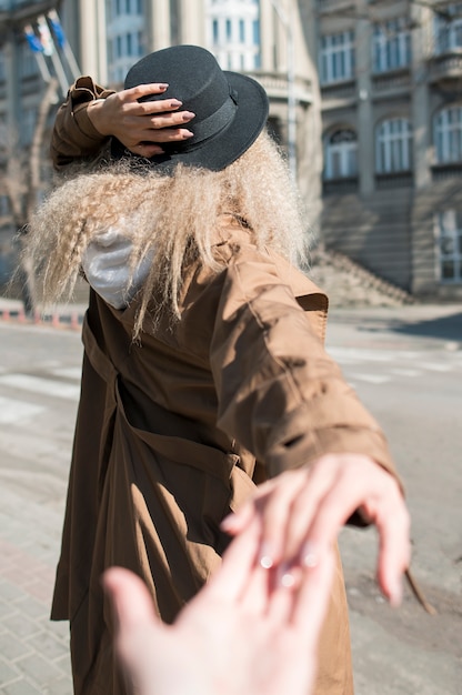 Rückansicht Frau mit dem lockigen Haar, das Hand des Freundes hält