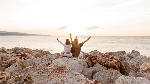 Rückansicht Freunde sitzen auf Felsen