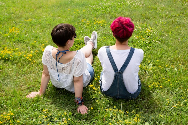 Rückansicht Freunde sitzen auf Gras