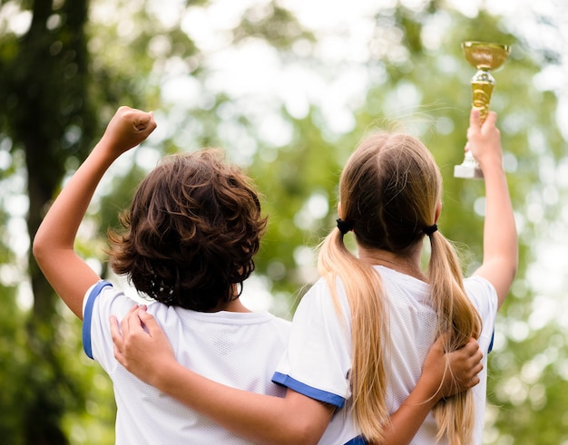 Rückansicht Kinder, die glücklich sind, nachdem sie ein Fußballspiel gewonnen haben