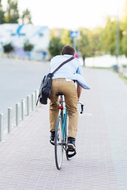 Rückansicht Mann, der Fahrrad draußen reitet