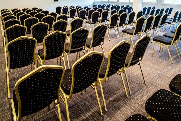 Rückansicht von Stühlen in einer Reihe ohne Personen im Konferenzsaal