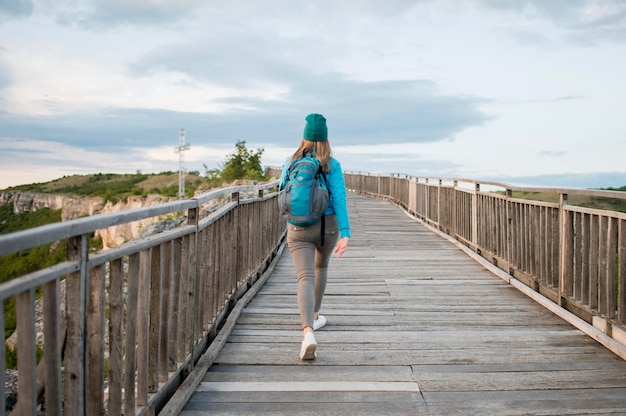 Rückansichtstourist, der die Brücke hinuntergeht