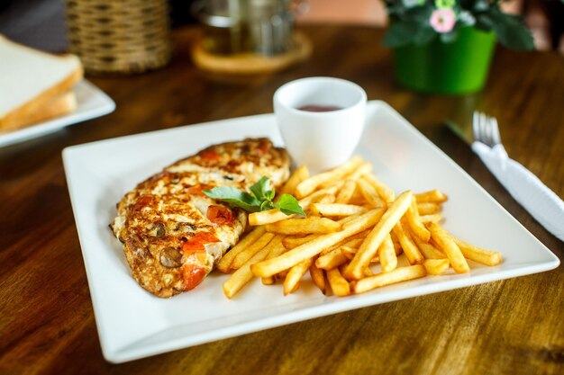 Rührei und Pommes Frites auf einem Holztisch