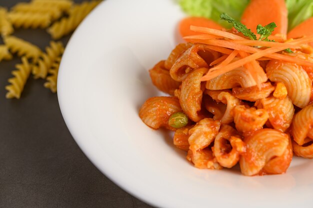 Rühren Sie gebratenes Makkaroni mit Tomatensauce und Schweinefleisch