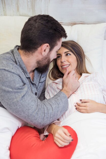 Rührendes Gesicht des jungen Mannes der Frau im Bett