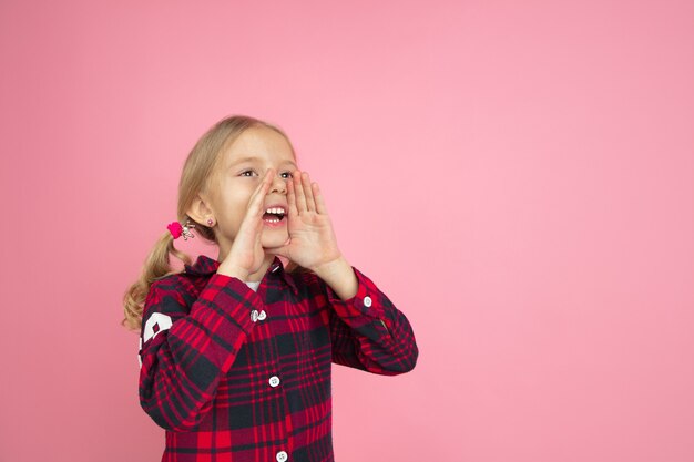 Rufen, schreien. Kaukasisches Porträt des kleinen Mädchens auf rosa Wand. Schönes weibliches Modell mit blonden Haaren. Konzept der menschlichen Emotionen, Gesichtsausdruck, Verkauf, Anzeige, Jugend, Kindheit.