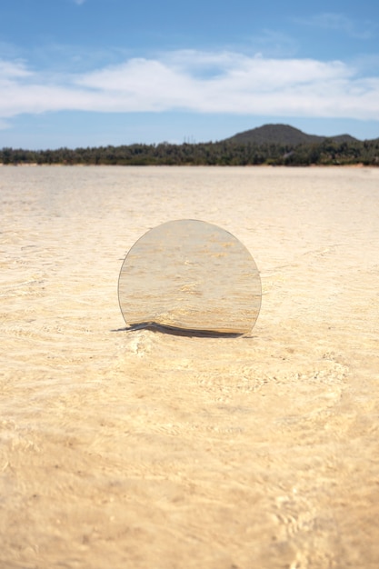 Runder Glasspiegel am Strand, der die Landschaft widerspiegelt