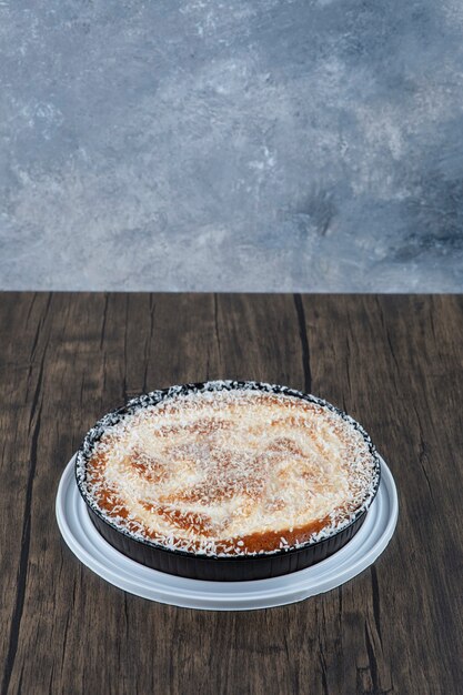 Runder köstlicher Kuchen auf einem Holztisch platziert.