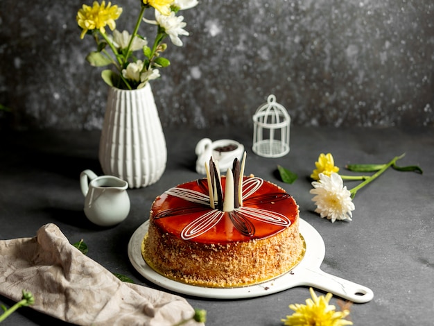 Runder Kuchen mit Karamellsirup weißen und dunklen Pralinen dekoriert