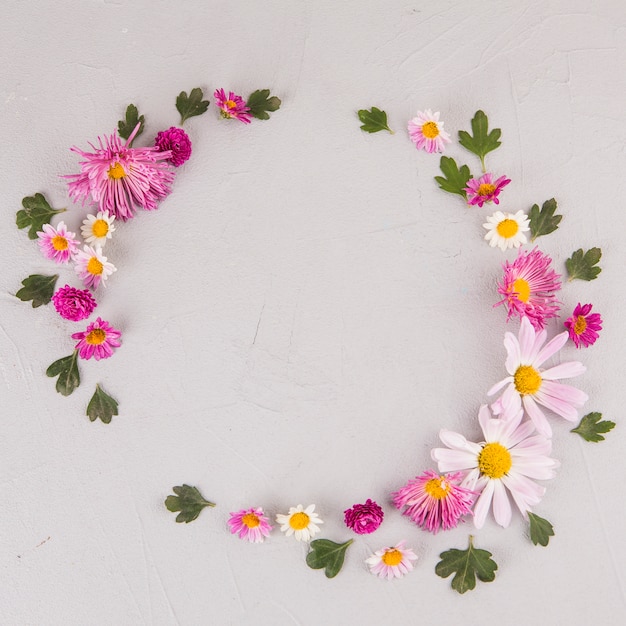 Runder Rahmen aus Blumen und Blättern auf dem Tisch