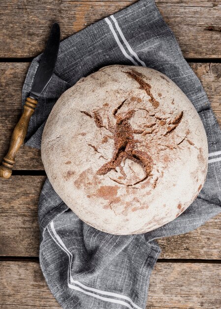 Rundes Brot der Draufsicht mit Messer auf Stoff