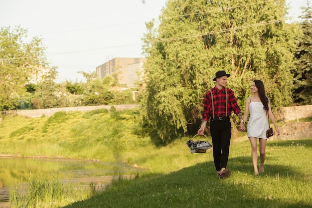 Runter gehen. Kaukasisches junges und glückliches Paar, das am Sommertag zusammen ein Wochenende im Park genießt?